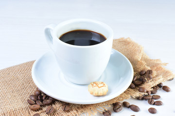 Colombian coffee cup with coffee beans on white wooden background