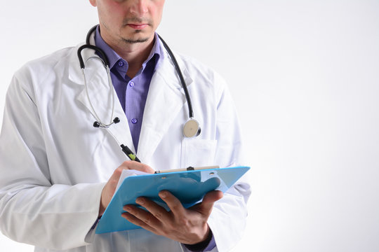 Cropped photo of Male Doctor standing with folder, isolated on white background. Middle aged Doctor holding clipboard isolated on white. Front view, copy space. Empty white background.