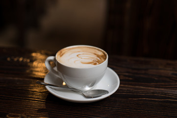 Cup of coffee latte on old wooden background