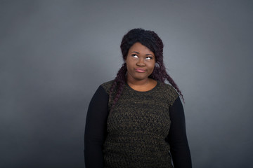 Gloomy, wondering young woman looking up with lips together, being upset thinking about something...