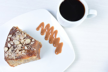 52/5000 Pecan and caramel cake on white wooden background