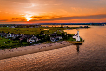 Summer sunset in Old Saybrook along the Connecticut River with Lynde Lighthouse in the foreground and a summer sunset - obrazy, fototapety, plakaty