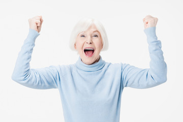 Excited mature lady feel euphoric and winning isolated on white studio background