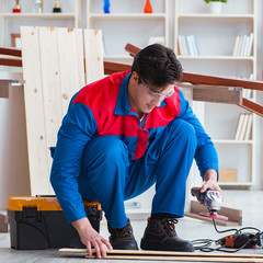 Young carpenter working with wooden planks