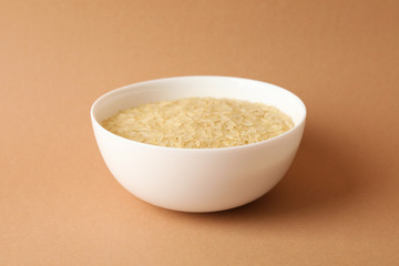 White bowl with rice on craft background, close up