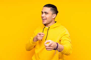 Asian handsome man isolated on yellow background laughing