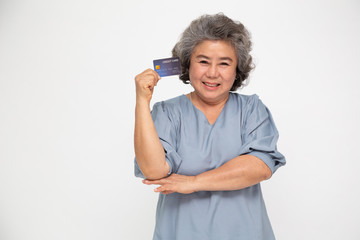 Portrait of senior asian woman holding credit card and showing on hand isolated on white background - Powered by Adobe