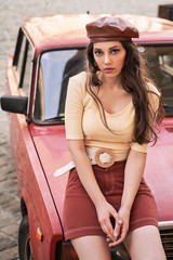 Young beautiful girl dressed in retro vintage style in the old european city