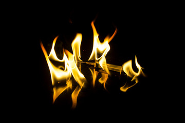 dancing flashes of flame with reflection on a black background