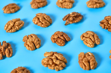 Scattered halves of pulp of walnut on blue background