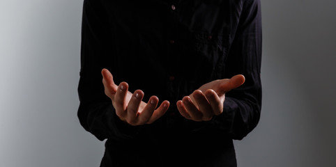 Handsome man sit prayer on black background. His hands are praying for God's blessings.