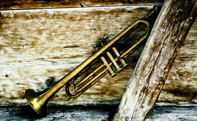 an ancient jazz trumpet with wooden background - obrazy, fototapety, plakaty