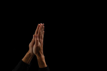 Fototapeta premium Handsome man sit prayer on black background. His hands are praying for God's blessings.