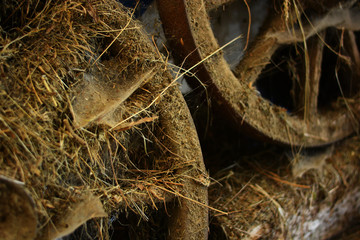 the wheels of a wagon covered in dust and hay