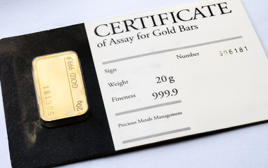Minted gold bar weighing 20 grams with certificate in blister package.