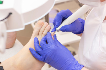 Therapeutic pedicure. Master podologist does hardware pedicure. visit to the podiatry. Foot treatment in the spa. Clinic of Podiatria.