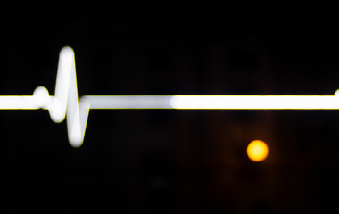 Pulse. Neon light on an office building with a reflection of the night lamp.