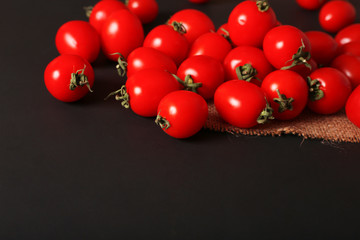 Small tomatoes sprinkled on a dark background