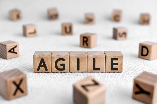 Agile - words from wooden blocks with letters, quickly and easily movement shrewd nimble  agile concept, white background