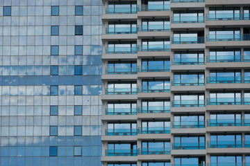 Spiegelung des Himmels in einer modernen Glasfassade mit Balkonen