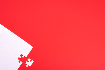A puzzle of white pieces with one seized element on a red background with place for your text