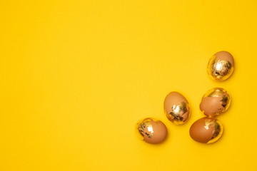 Golden eggs on a yellow background, top view, flat. Happy holiday celebrate