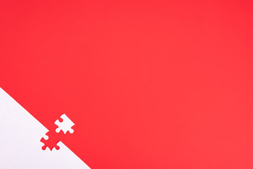 A puzzle of white pieces with one seized element on a red background with place for your text