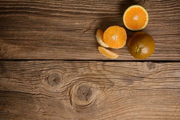 Dark orange isolated on wooden background. Brown oranges.