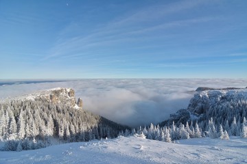 Background photo of low clouds in a mountain valley, vibrant blue and orange sky.