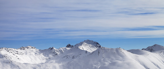 Panoramic view on snowy slope in high winter mountains