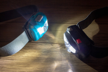 A pair of led headlamps turned on facing each other showing the light beams