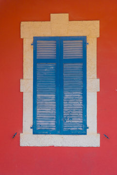 Blue wooden shutters and red wall in Larnaca, Cyprus