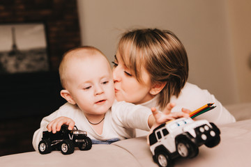 Mom and her toddler son plays with car.
