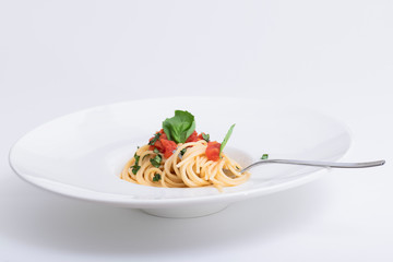 Spaghetti dish with basil, tomato and shredded herbs