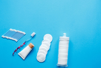  Hygiene products and daily routine. Toothbrush with bacterial protective cover, cotton swabs and ctoothbrush on a blue background with top view and copy space