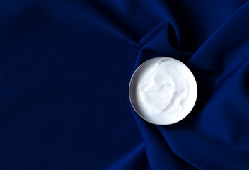 Cosmetic facial care concept. Luxury face cream moisturizer for sensitive skin, spa cosmetics and natural skincare product. Over Phantom Blue siphoned background