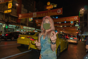 Fototapeta premium .Chinatown Bangkok,Thailand - February 04,2020: .A lady dress stylishly lady wear health mask standing in the Chinatown on Yaowarach road Bangkok Thailand