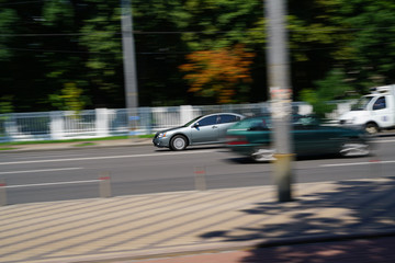 Modern cars motion at the city street on sunny day,  Kiev, Ukraine. City traffic.
