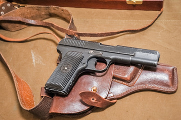 a black pistol is lying on a brown caboose,a black firearm is holstered