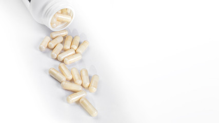 medicine bottle open with pills on white background