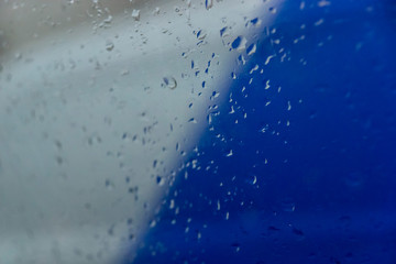 frozen glass with water drops and a blurry background of white and blue