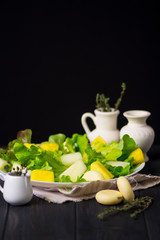 lettuce salad with pineapple and melon, cheese on a wooden background