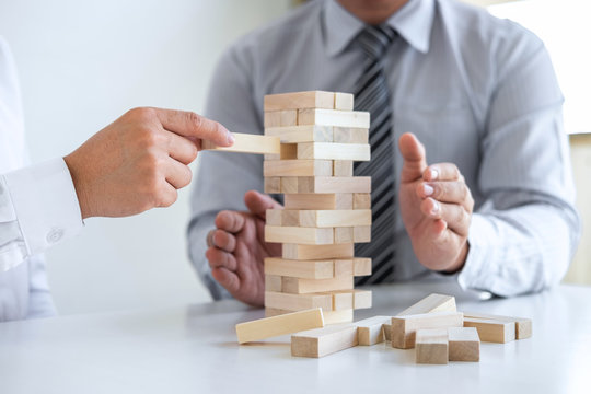 Planning Risk and Strategy in Business, Image of two Businessman hand placing making wooden block structure growing up the tower and protection to planning and development to successful
