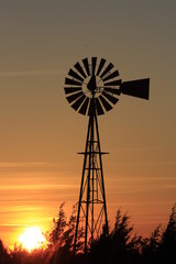 Colorful Kansas Sunset with Sky, and Windmill silhouette west of Nickerson Kansas USA out in the Country.