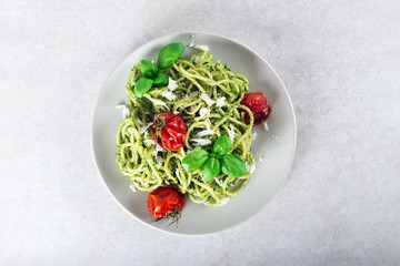 Pasta spaghetti with homemade pesto sauce, roasted tomatoes and fresh basil leaves, vegetarian food