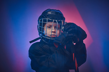 Young blonde fit boy, ice hockey player, posing in a bright neon studio for a photoshoot, wearing...