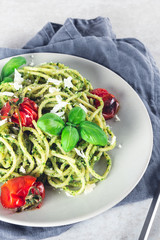 Pasta spaghetti with homemade pesto sauce, roasted tomatoes and fresh basil leaves, vegetarian food