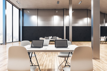 Minimalistic coworking office interior with laptops
