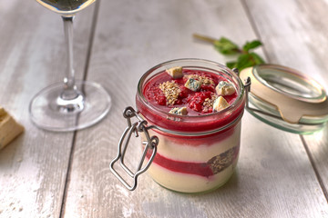 Raspberry - cheese panakota, with a glass of white wine, cheese, mint, on a white board
