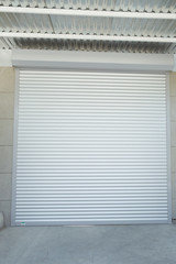 Shutter door or roller door and concrete floor outside .White Automatic shutters in a house . gates in the garage . Automatic Electric Roll-up Gate Or Push-up Door In Ground Floor .